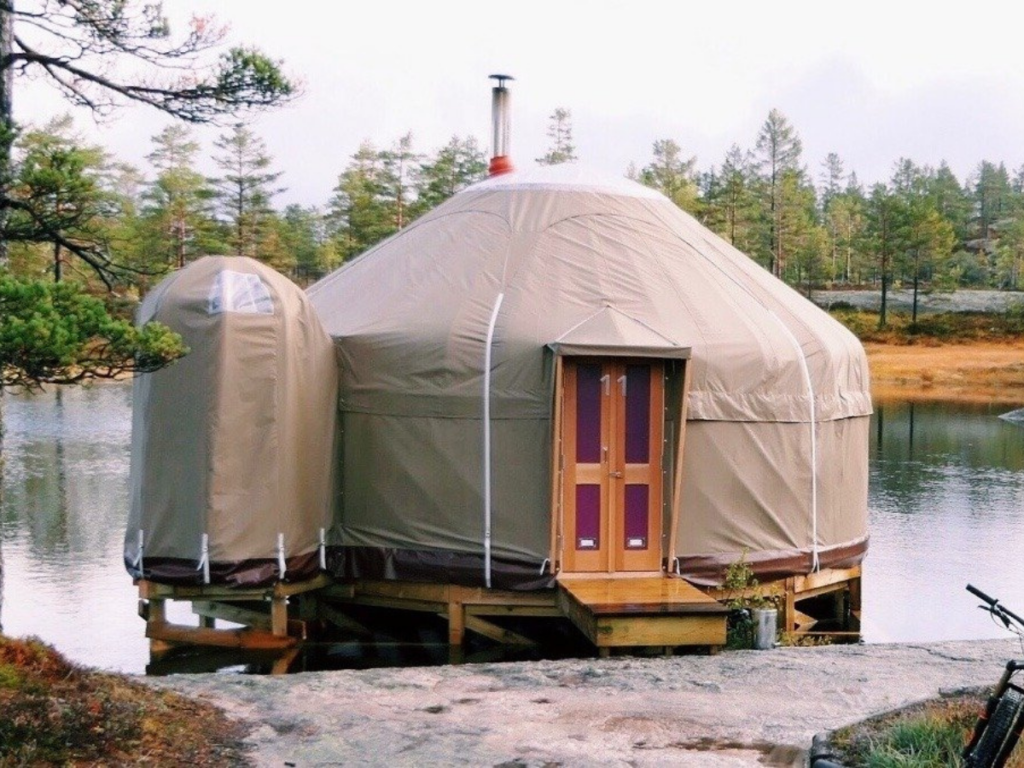 A glamping structure sitting on top of a lake.
